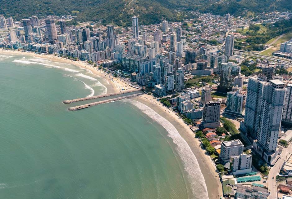 Canto da Praia, Itapema/SC — orla com mar e morros característicos do litoral norte de Santa Catarina